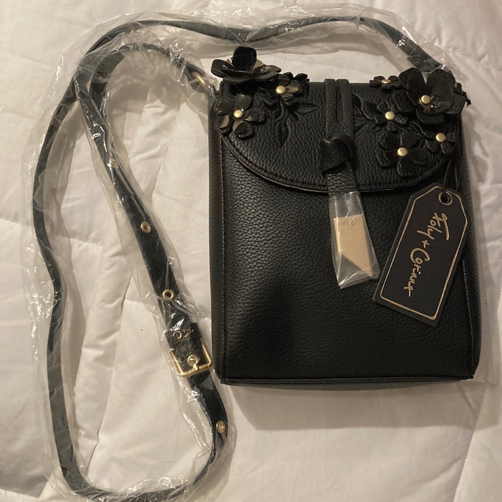 NWT black Foley+Corinna Lila Phone Bag with floral design.